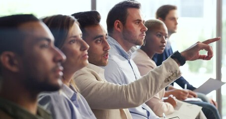 Professional businessman raise hand to ask question in conference seminar, sitting with work colleagues in modern office. Diverse group of employees listening in strategy training presentation.