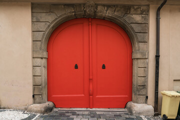 Fototapeta na wymiar Bright vintage orange colored wooden door entrance of building garage front view outdoor
