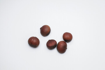 Chestnuts on white background. Pile of fresh chestnuts ready to roast. Top view, copy space. Flat lay. Space for text