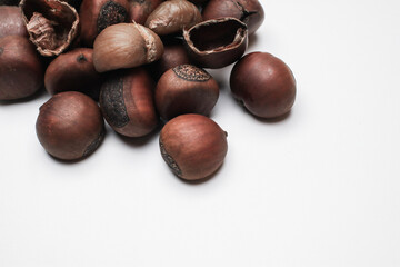Chestnuts on white background. Pile of fresh chestnuts ready to roast. Top view, copy space. Flat lay. Space for text
