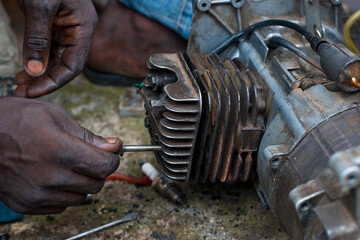 An Engineer working on a small electricity generator in an engineering workshop, undergoing repair...
