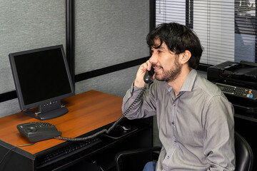 Young employee talking on the phone in the office