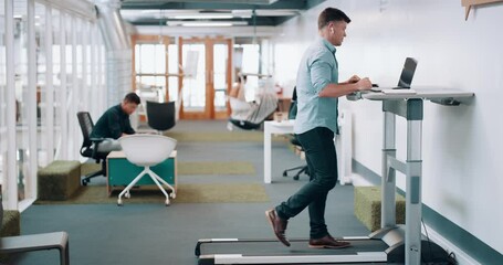 Trendy corporate man multitasking work, listening to music while doing leg fitness for healthy life. Busy businessman exercising on a treadmill desk while working on laptop in modern office workplace - Powered by Adobe