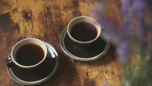 テーブルの上のコーヒーカップとラベンダーの花束