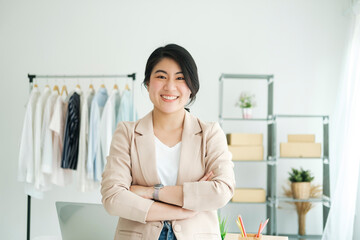 Happy young asian female freelan standing in online clothing store.