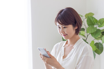 Fototapeta premium スマホを操作する笑顔の女性
