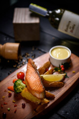 Salmon steak fried with vegetables on wooden table