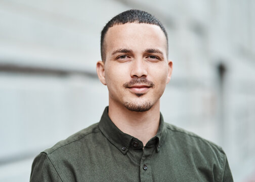 Closeup face of a serious, motivated and ambitious man standing outside in a city, town or downtown alone. Portrait, headshot and face of social worker or volunteer looking forward with trust or care