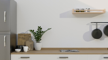 A modern wooden kitchen tabletop with kitchenware and copy space over the white wall. close-up image.