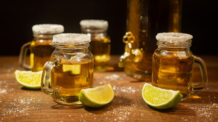 tequila shots served in jars with salt and lime on wooden table