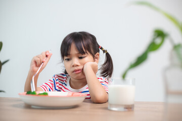 Nutrition & healthy eating habits for kids concept. Children do not like to eat vegetables. Little...