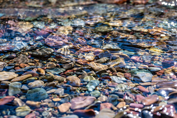 Rainbow multi-colored rocks in Avalanche creek leading towards Lake McDonald at Glacier National Park, Montana, USA