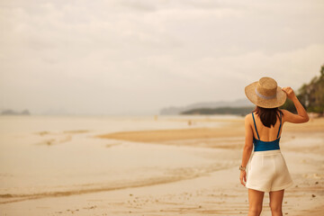 Woman tourist walking at Paradise beach on Islands at sunset. destination, wanderlust, Asia Travel, tropical summer, vacation and holiday concept