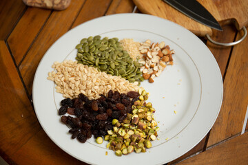 Close up shot a dish full of different seeds and nuts, chestnut,almond, raisin, pumpkins, seasame. Healthy eating concept 