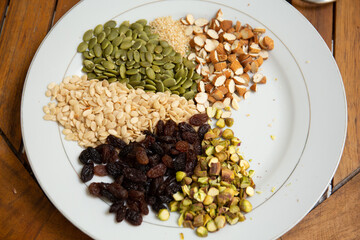 Close up shot a dish full of different seeds and nuts, chestnut,almond, raisin, pumpkins, seasame. Healthy eating concept 