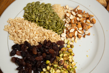 Close up shot a dish full of different seeds and nuts, chestnut,almond, raisin, pumpkins, seasame. Healthy eating concept 