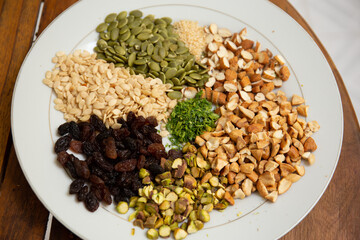 Close up shot a dish full of different seeds and nuts, chestnut,almond, raisin, pumpkins, seasame. Healthy eating concept 