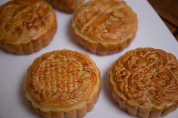 Retro vintage style Chinese mid autumn festival foods. Traditional mooncakes on table setting
