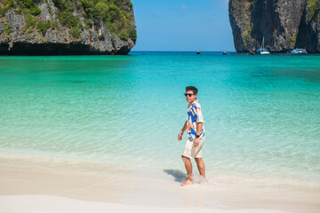 happy tourist man at Maya Bay beach on Phi Phi island, Krabi, Thailand. landmark, destination Southeast Asia Travel, vacation and holiday concept