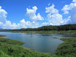Fototapeta premium Village in the lake and clear mountain cool water with blue sky and clouds, National Park in Thailand