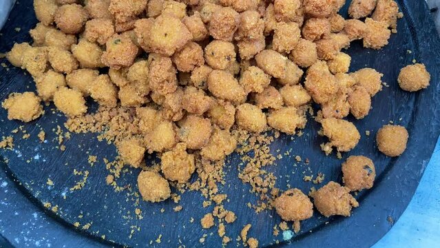 Moong dal pakora presented on a large wooden dish for sale in Kolkata, India. Selective focus