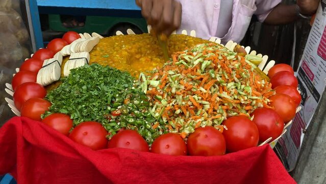 A close up shot of a man selling Kolkata's renowned Ghugni chat, or chickpea curry, on the street. India. No face video