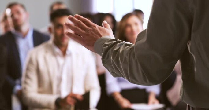 Businessman giving a presentation to coworkers at a corporate conference. Closeup of an executive using hand gestures while speaking to his team. Professional leader talking in a business meeting.