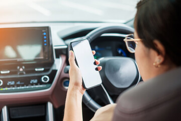 Woman hand holding smartphone while driving car. Dangerous, Journey, trip and Transportation concepts