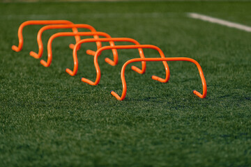 Sports Training Hurdles in a Line on Artificial Sports Field. Soccer Football Training Equipment