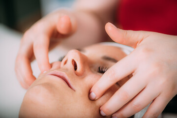 Face lifting massage, beautiful woman getting face lifting massage in a beauty salon.