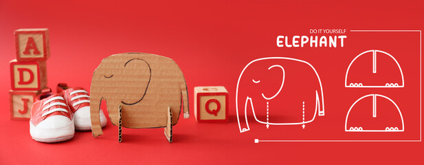 Handmade cardboard elephant toy on red background