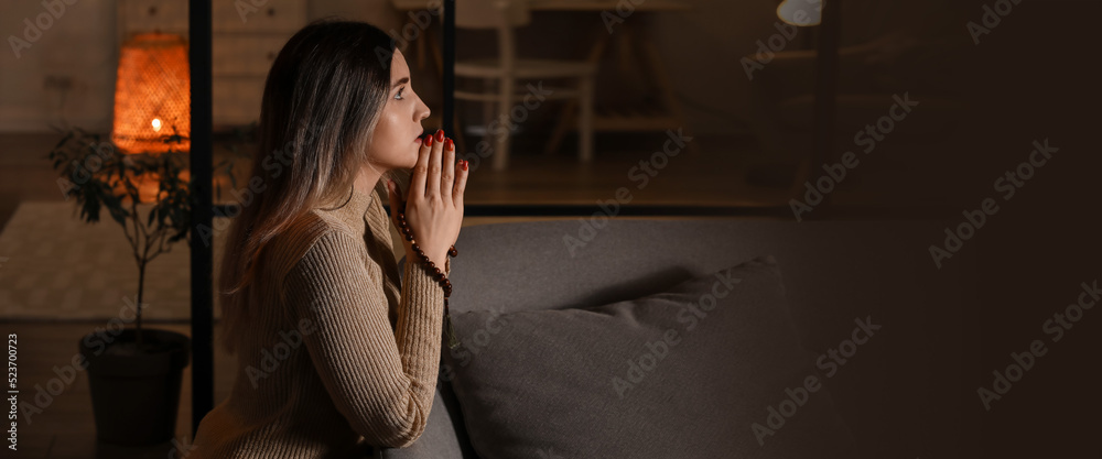 Canvas Prints religious young woman praying to god at home in evening