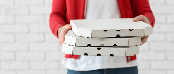Delivery man holding cardboard pizza boxes on white background, closeup
