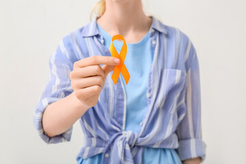 Woman with orange awareness ribbon on white background. Kidney cancer concept