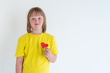Sweet little girl with Down Syndrome, playing with paper heart. world down syndrome day background....