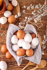 Bowl of white and brown chicken eggs on wooden background