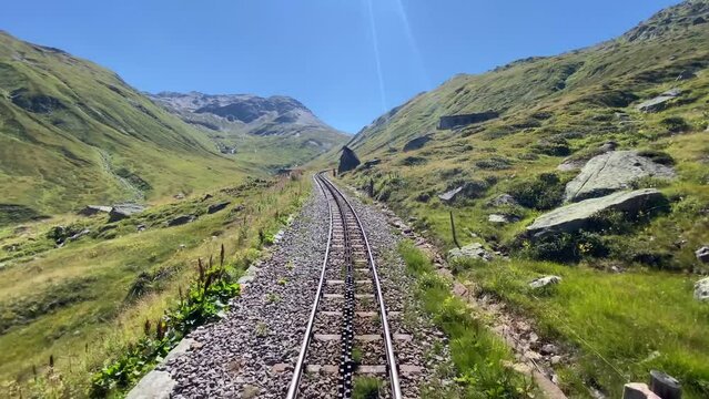 Steam railroad in the Swiss Alps goes over the Furkapass with a Rack and Pinion railroad. The old railroad line runs high above the mountains