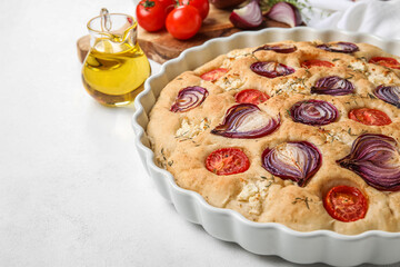 Baking dish of tasty Italian focaccia on light background, closeup