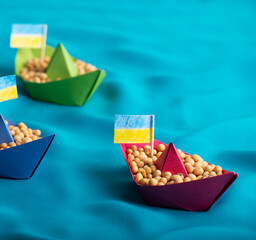 Boats with Ukrainian soybeans made of paper origami concept