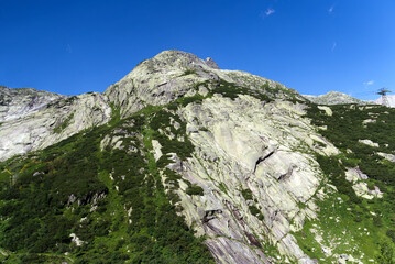 Fototapeta na wymiar Mountain panorama at Swiss mountain pass Grimsel, Canton Bern, on a sunny summer day. Photo taken July 3rd, 2022, Grimsel Pass, Switzerland.