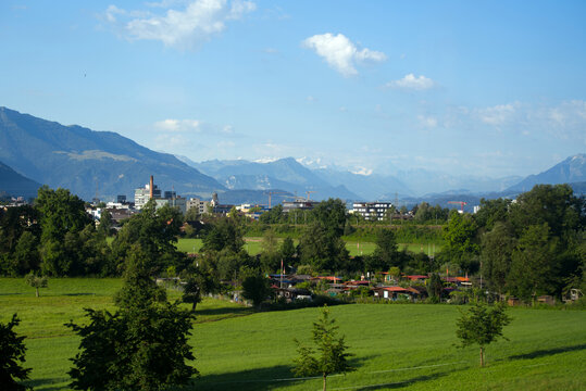 Skyline of City of Baar and Zug with Swiss Alps in the background on a sunny summer day. Photo taken June 25th, 2022, Zug, Switzerland.