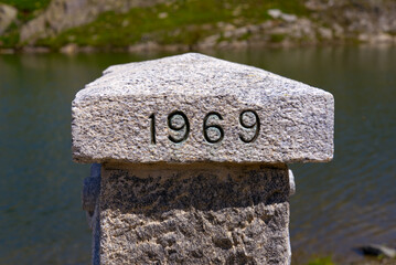 Marker stone at frontier between Canton Valais and Canton Ticino with engraved year 1969 at Nufenen...