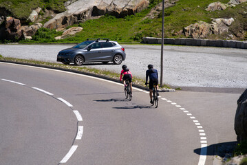 Bicycle couple on the way down form Swiss mountain pass Grimsel on a sunny summer day. Photo taken July 3rd, 2022, Grimsel Pass, Switzerland.