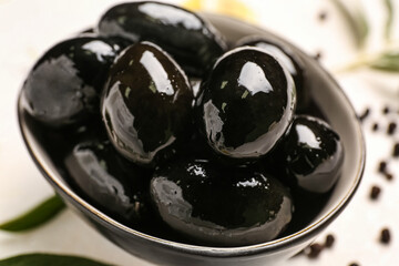 Bowl of tasty black olives, closeup