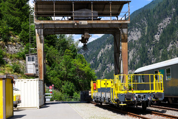 Cargo railway wagon with crane at railway station of mountain village Göschenen on a sunny summer...