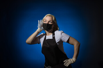 A gardener woman in a black apron, gloves in a protective mask eavesdrops on a dark background.