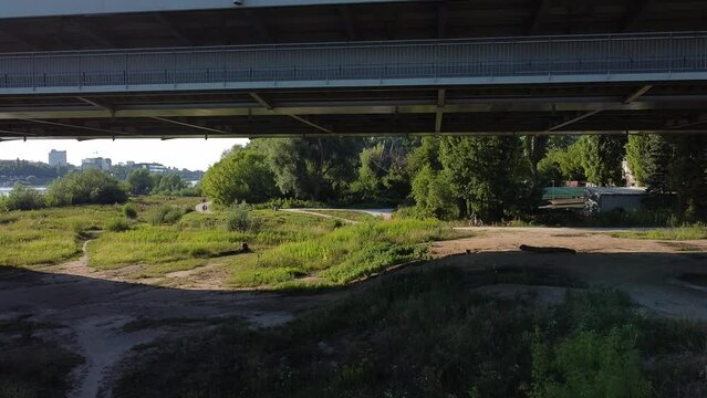 Aerial drone shot of under the bridge while a person carries and walks looking to vista river Warsaw Poland