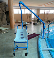 Swimming pool chair for wheelchair users. Special lifter chair for disabled users.