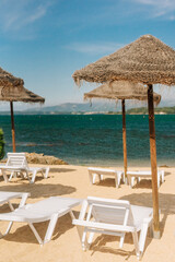 Deck chairs with straw parasols near the river