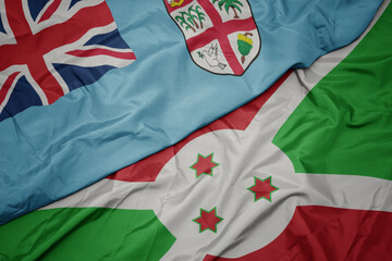 waving colorful flag of burundi and national flag of Fiji .